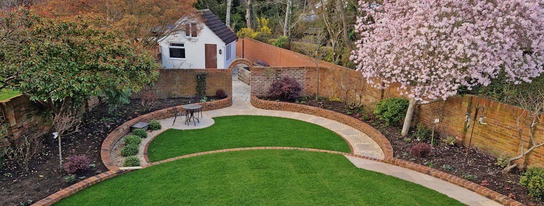 Wedge-shaped garden with split level lawn and mature magnolia in full bloom