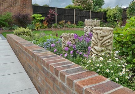 Accessible garden with a porcelain paved ramp, Māori inspired decorative heads and colourful planting