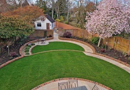 Wedge-shaped garden with split level lawn and mature magnolia in full bloom