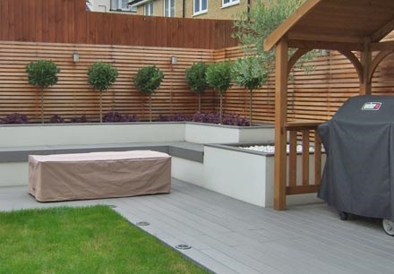 Contemporary BBQ area with composite decking and rendered planters with integrated bench seating
