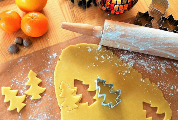 Biscuit dough rolled flat and shapes cut out with a Christmas tree shaped cutter